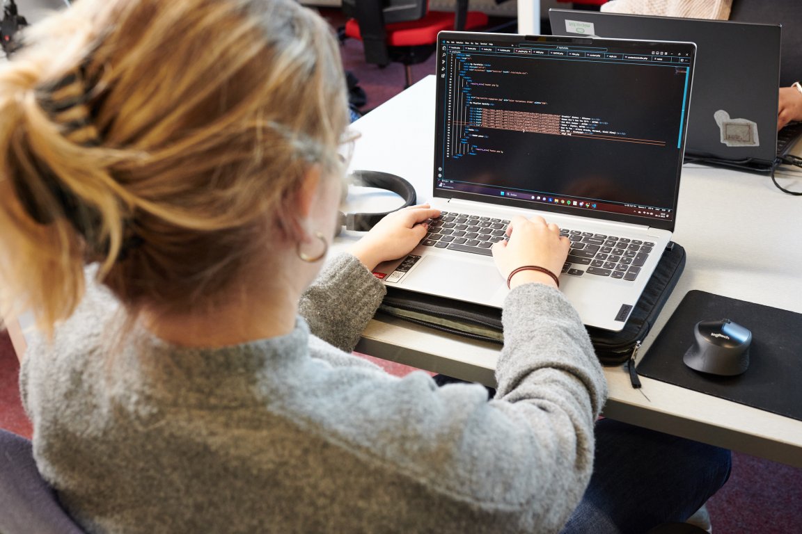 Student learning software development on a laptop